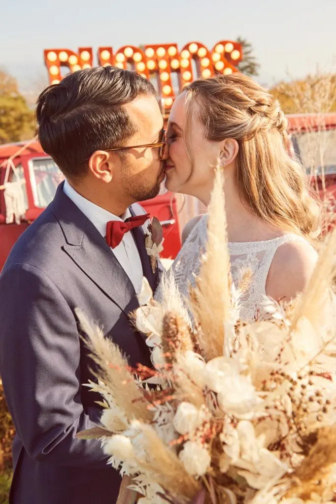 Brautpaar auf der Juckerfarm welche sich vor dem Photobus küssen