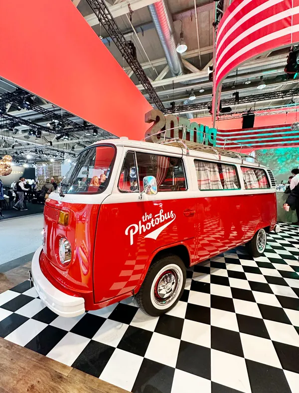 Roter Photobus Lady in Red (Fotobox) am Retro-Stand von Transgourmet an der IGEHO Basel 2025 auf schwarz-weiss gekacheltem Boden.