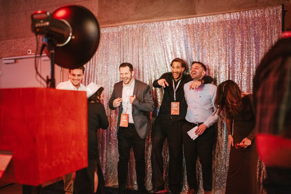 Verschiedene Gästegruppen lachen gemeinsam bei der Fotobox.