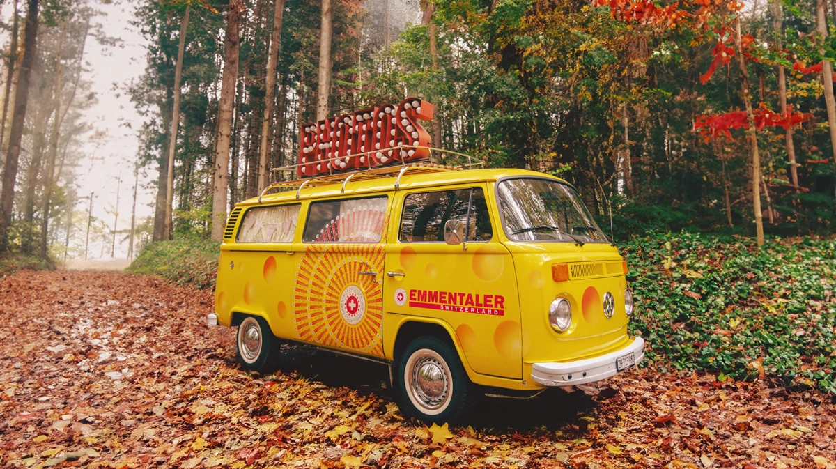 Gelber VW Photobus mit Emmentaler Vollfolierung im Käse-Design als Beispiel für kreatives Brand Branding im CI.