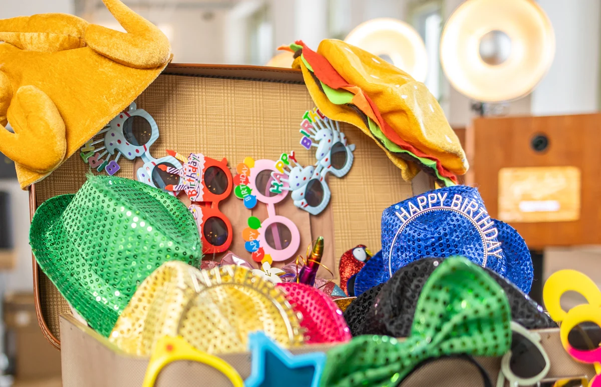Requisiten-Koffer mit Geburtstags-Accessoires für die Fotobox mieten am Geburtstag: Happy Birthday Hüte, bunte Brillen und Glitzerhüte von Photobus Schweiz