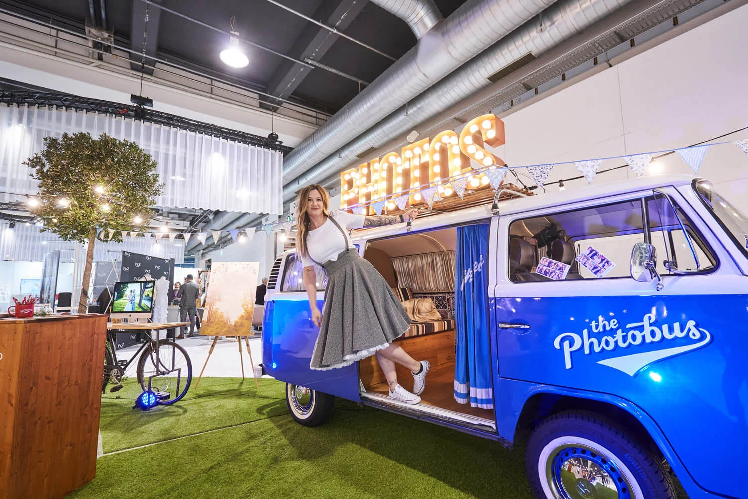 Photobus VW-Bus als Fotobox an einem Messestand in einer Schweizer Messehalle mit Besuchern