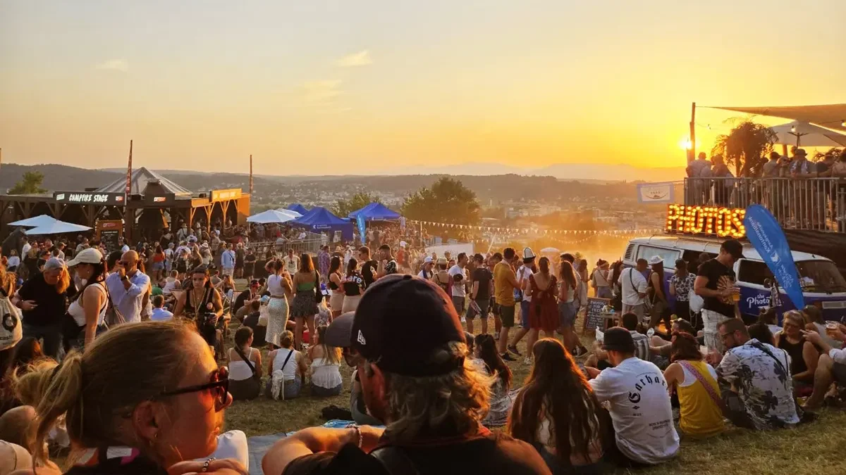 Photobus VW-Bus mit PHOTOS-Schild am Heitere Openair Aargau bei goldenem Sonnenuntergang und Festivalstimmung