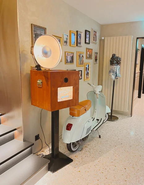 Photobus Holzfotobox in eleganter Hotel-Lobby neben einer weissen Vespa und Wandbildern, Ringlicht leuchtet